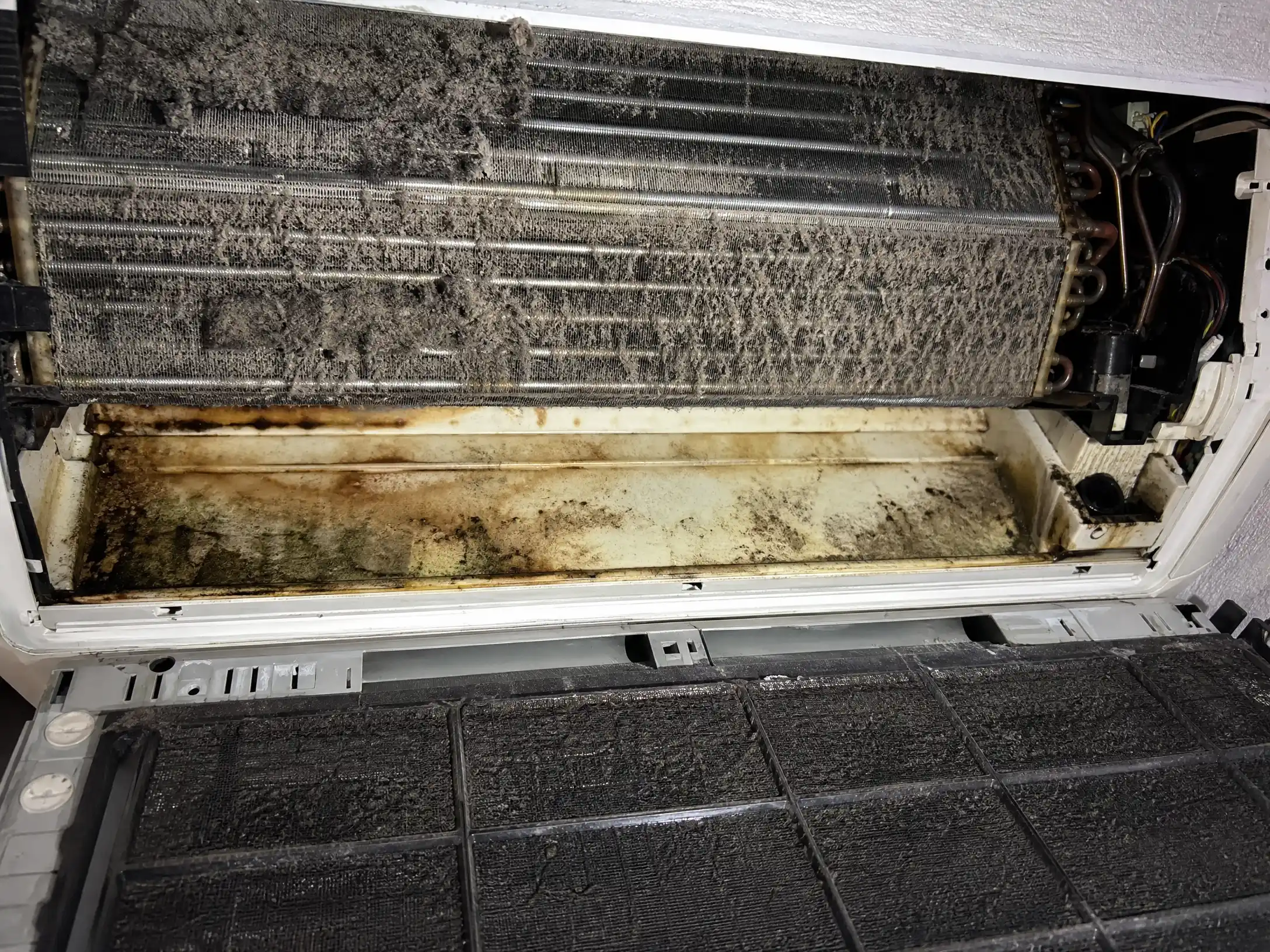 Fan-Coil-Wärmetauscher vor der Reinigung — zugesetzte Lamellen, Kondensatwanne